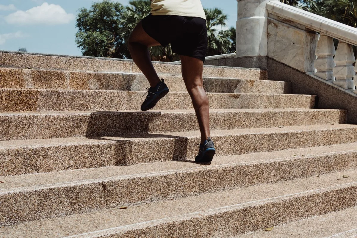 A runner climbing outdoor stone stairs